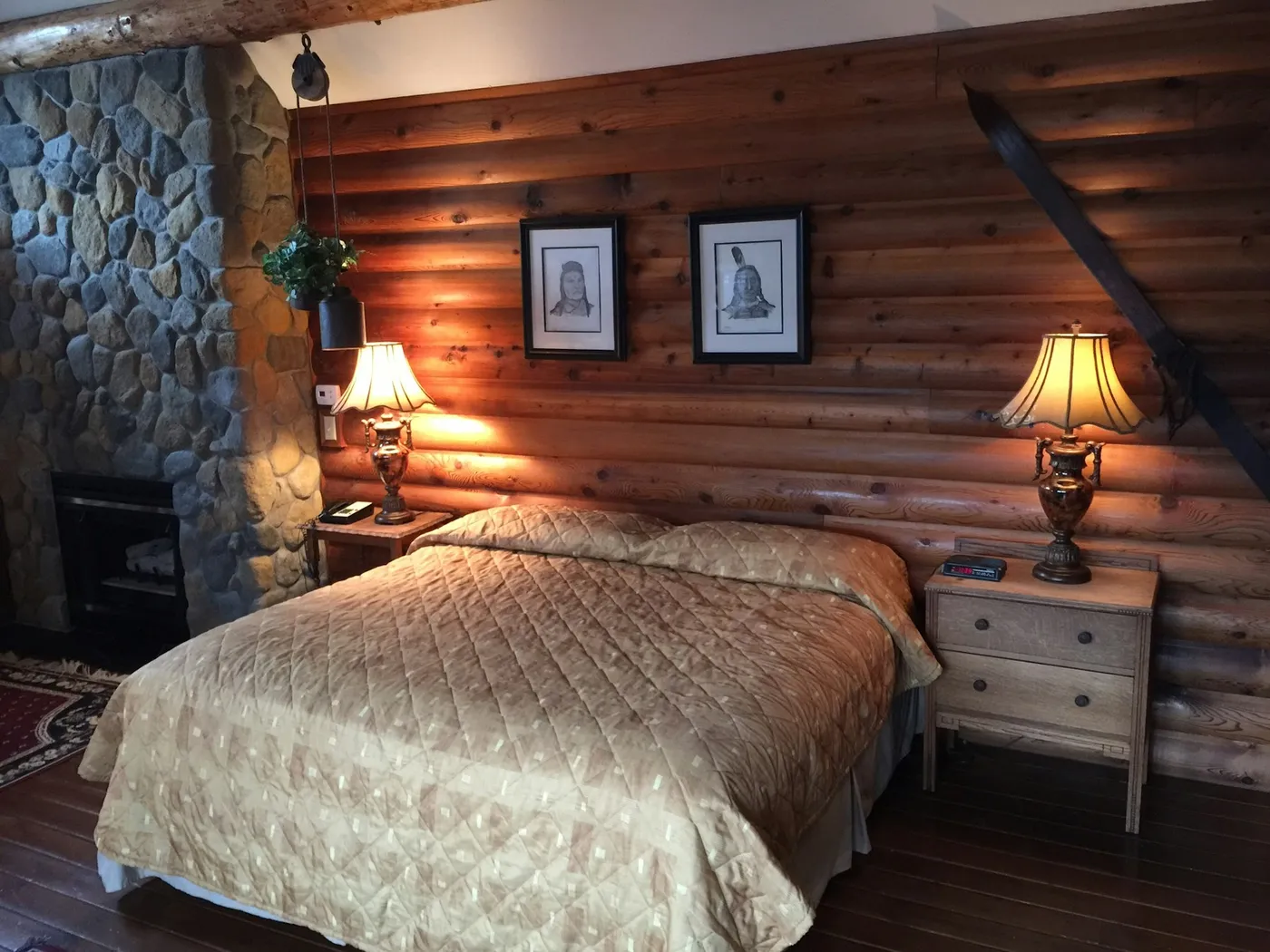 The Mt. Baker Room’s king bed beside a stone fireplace
